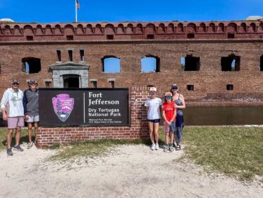 National Parks Mom family at the NPS sign for Dry Tortugas National Park, Florida