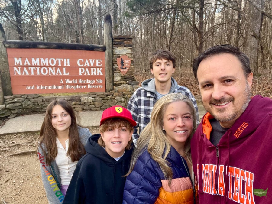 family in front of the Mammoth Cave National Park sign in Kentucky