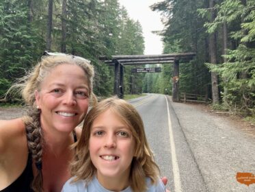 mom and child in front of the Mt. Rainier park entrance sign