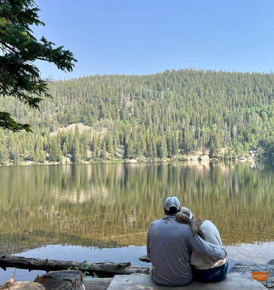 couple resting on the shore of Bear Lake in Rocky Mountain National Park, Colorado