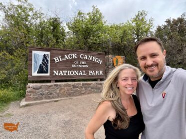 couple in front of NPS entrance sign for Black Canyon of the Gunnison National Park